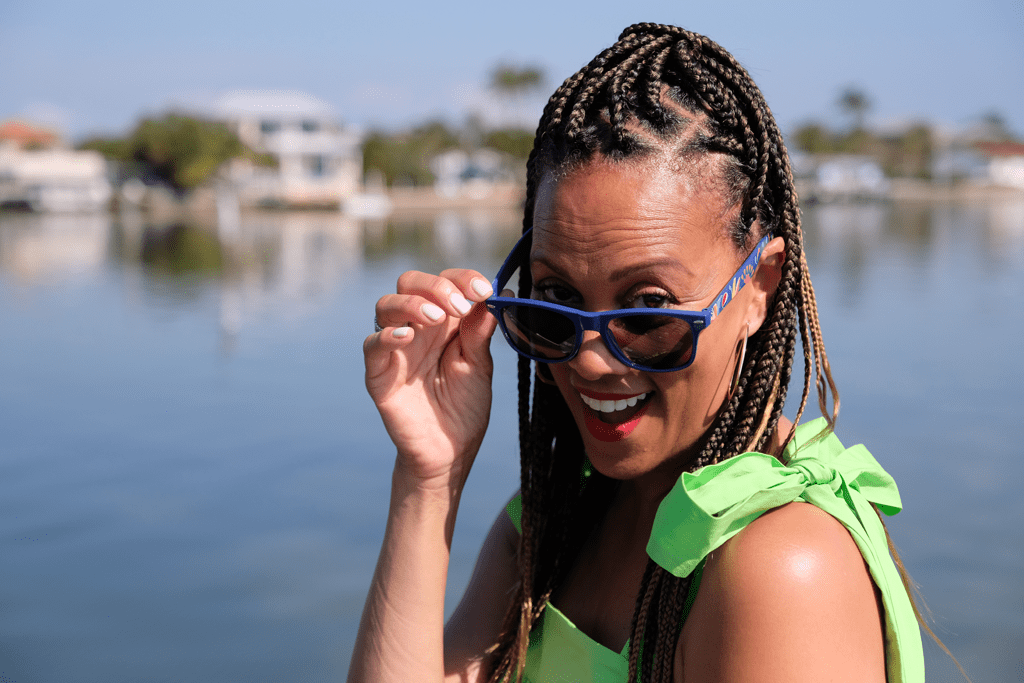 PPW Expo host Anji Corley peeks over a pair of branded sunglasses with a smile