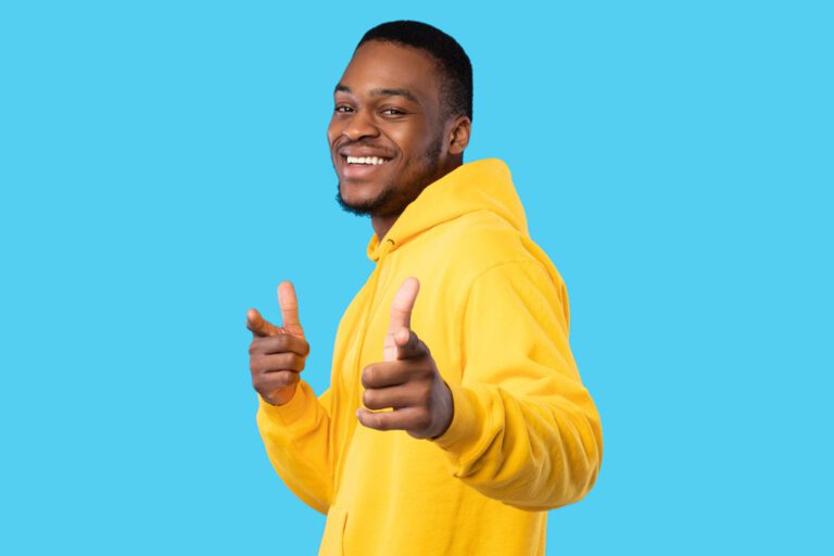Hey, You. Positive African American Young Man Pointing Fingers Looking At Camera Standing Posing On Blue Studio Background. You're Next Gesture. I Choose You Concept