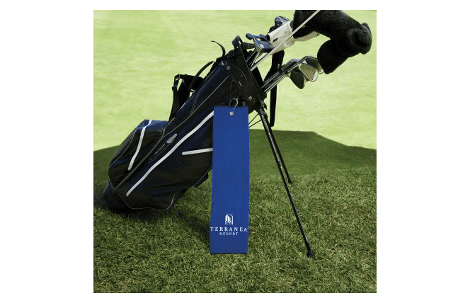 custom golf towel hanging from a golf bag on the green