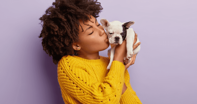 woman kissing puppy