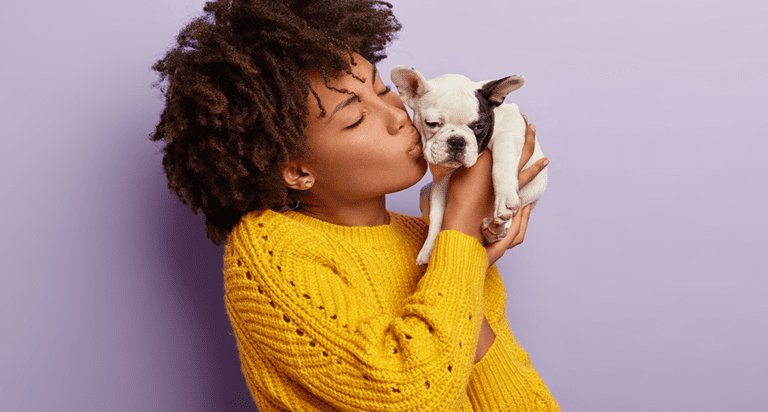 woman kissing puppy