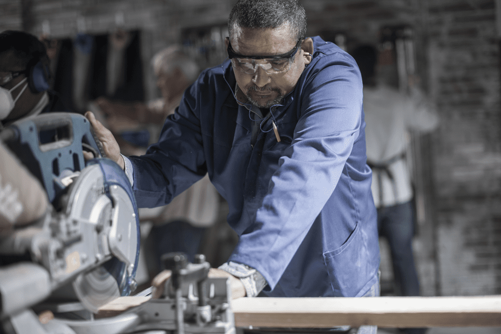 carpenter sawing in workshop