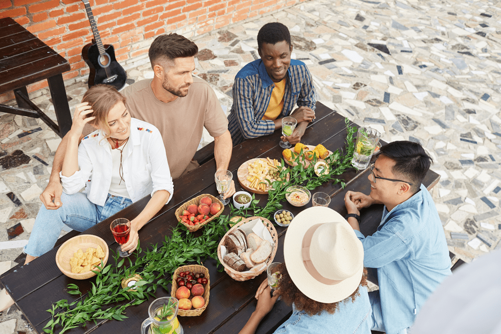 multi-ethnic group of young people enjoying dinner outdoors