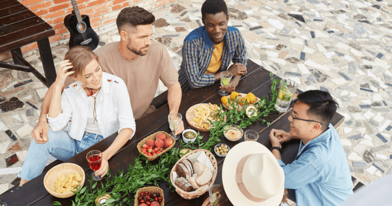 multi-ethnic group of young people enjoying dinner outdoors