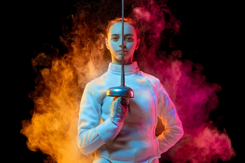 teenage girl in fencing gear with foil in hand
