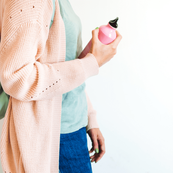 woman with backpack carrying reusable water bottle