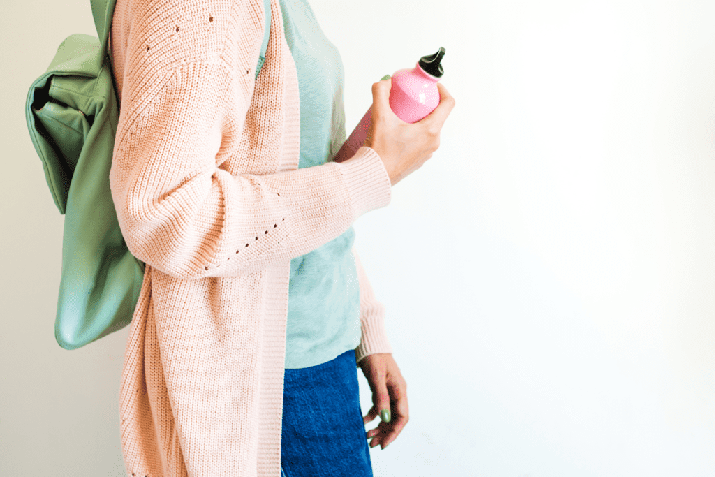 woman with backpack carrying reusable water bottle