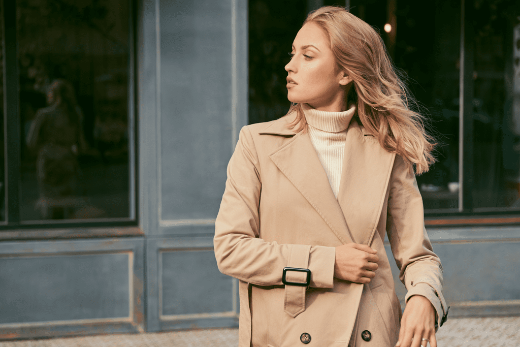 blonde woman in camel trench coat - stealth wealth - quiet luxury