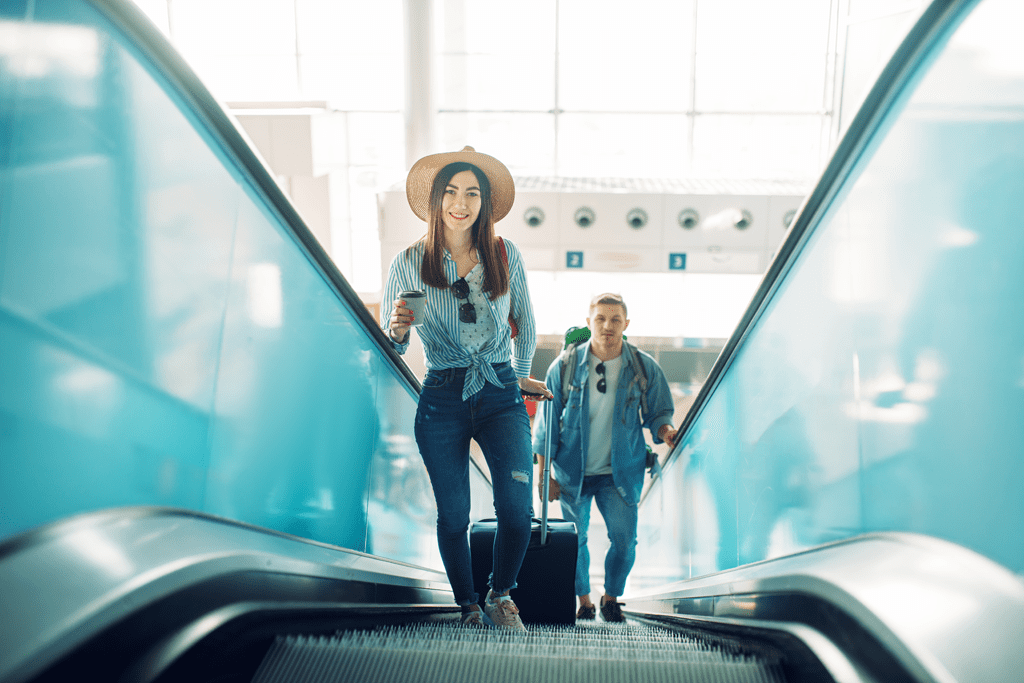 couple with luggage on airport escalator