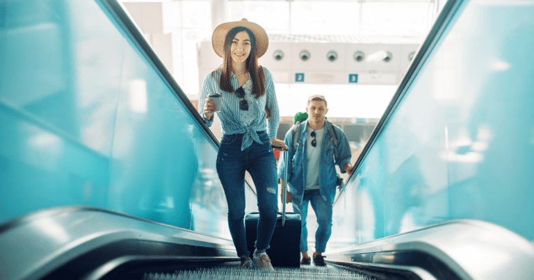 couple with luggage on airport escalator